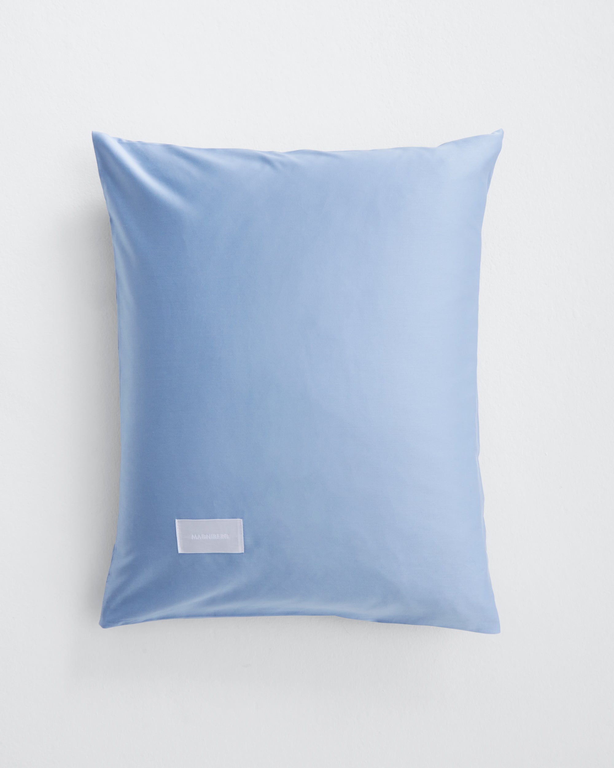 Pure pillow case in Haze Blue cotton sateen tightly woven soft comfortable. Sleek minimal design with few visible stitches for a calm bedroom. Magniberg